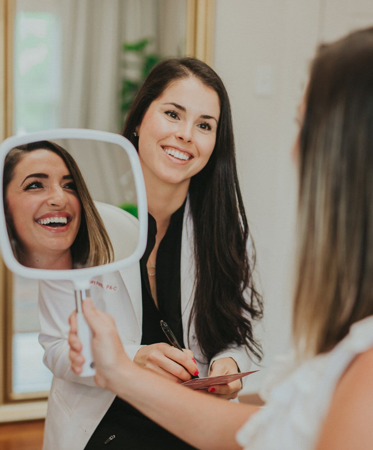 Woman smiling into mirror during consultation